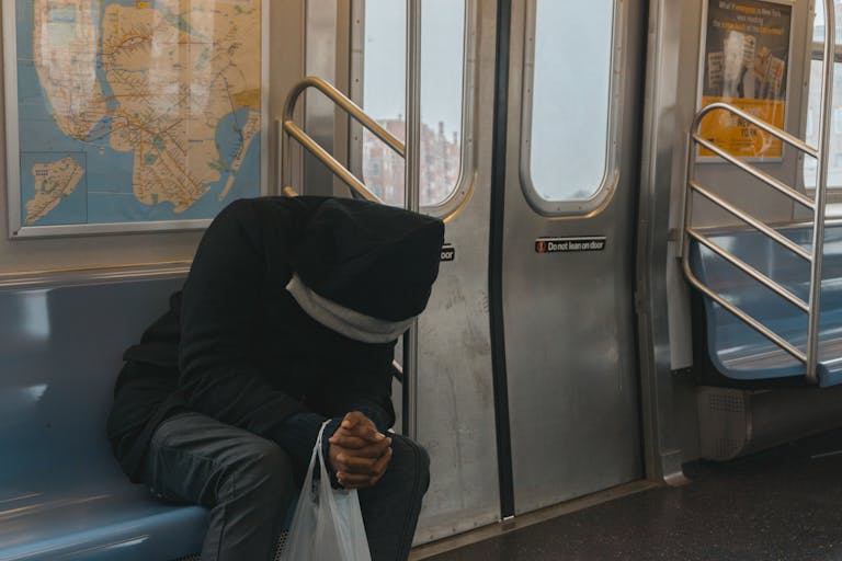 A lone passenger sitting in a New York City subway train, evokes feelings of solitude and reflection.