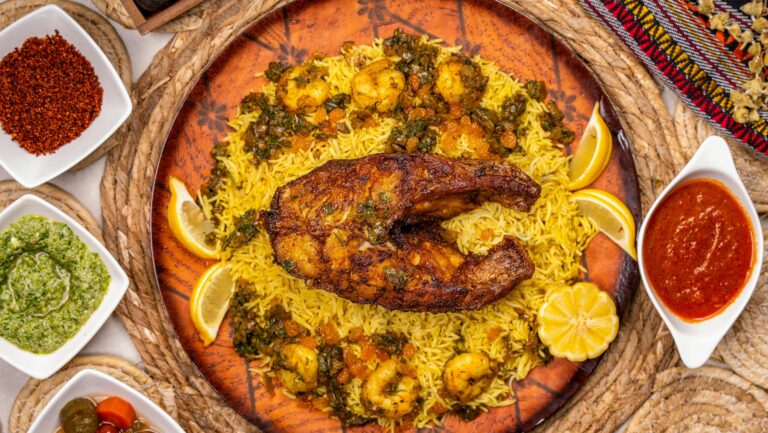 Colorful top-view shot of spiced fish and rice with various sauces and garnishes.